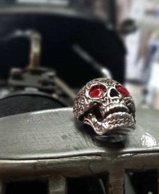 Anillo con forma de calavera apoyado sobre una chapa