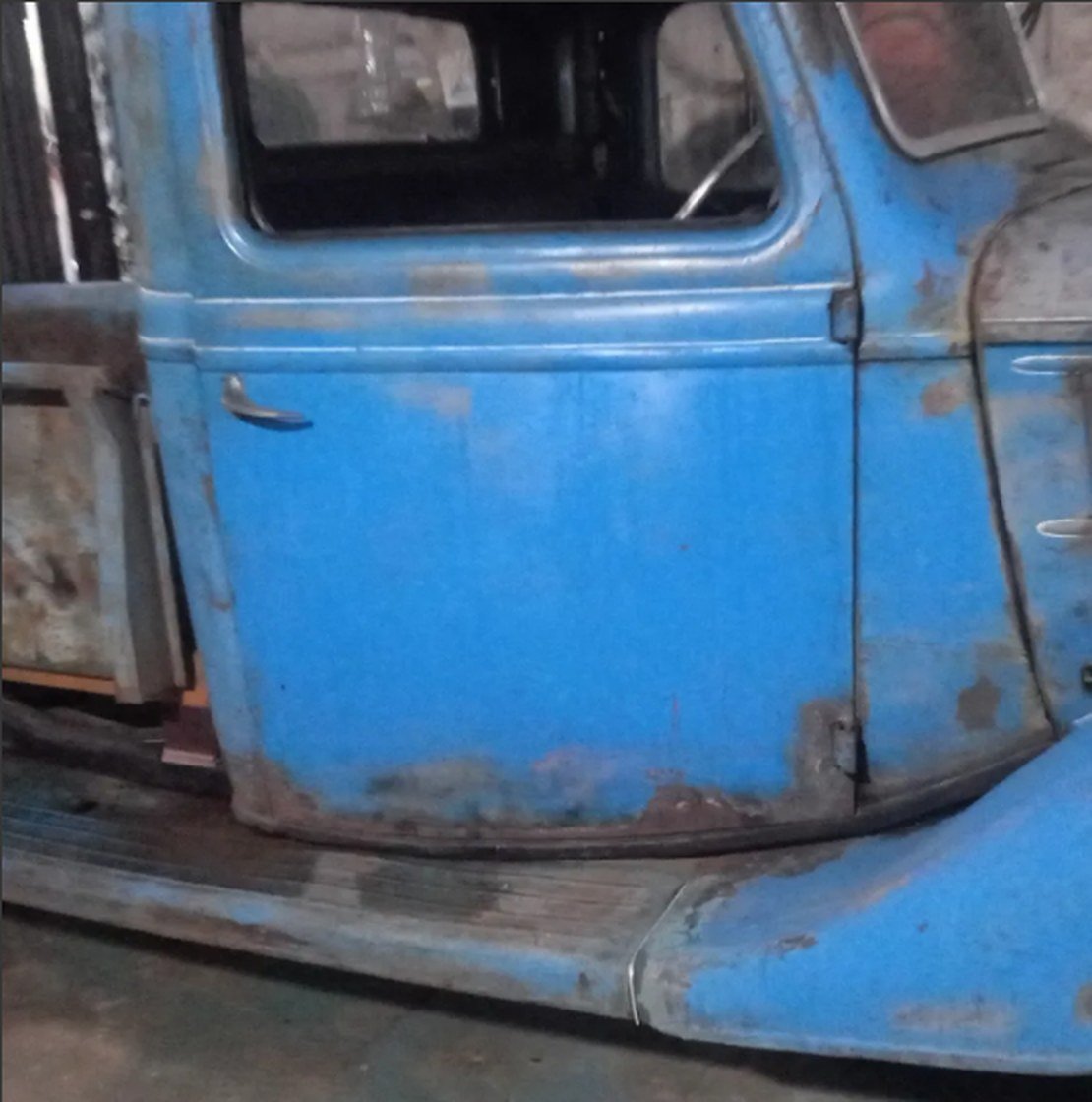 Puerta y estribo de una Ford 37 azul con el óxido a la vista